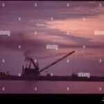 DREDGE BARGE AT WORK INSIDE BREAKWATER OF CONSUMER POWER PLANT AT